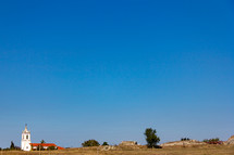 An isolated church near Conimbriga in Portugal under a cloudless blue sky