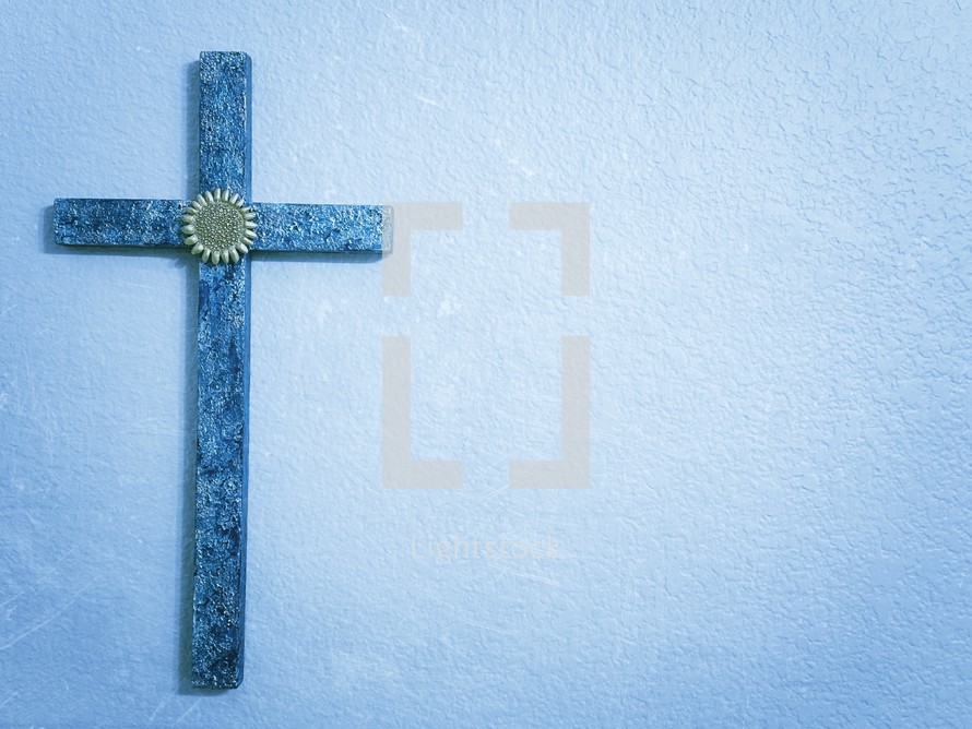 Blue textured cross on a blue background with copy space