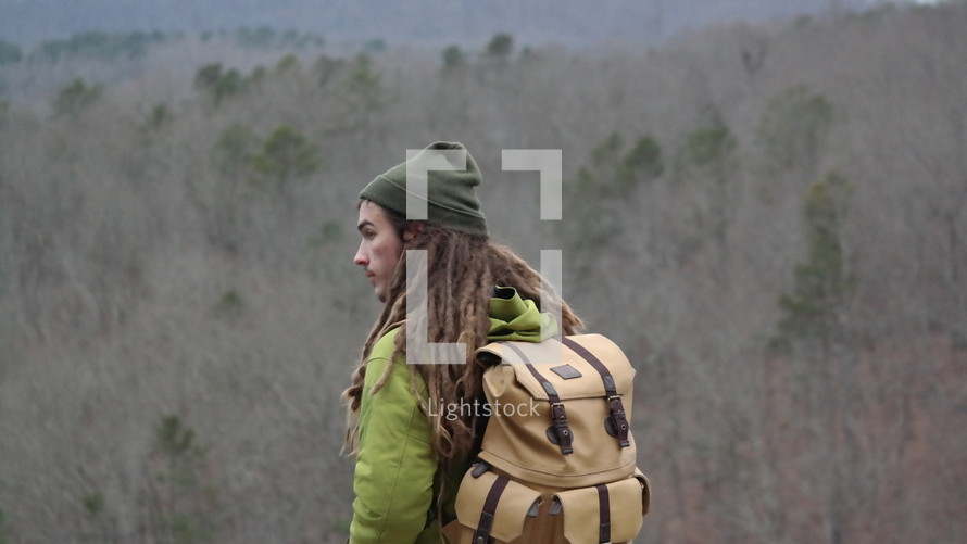 a man with dreads backpacking 