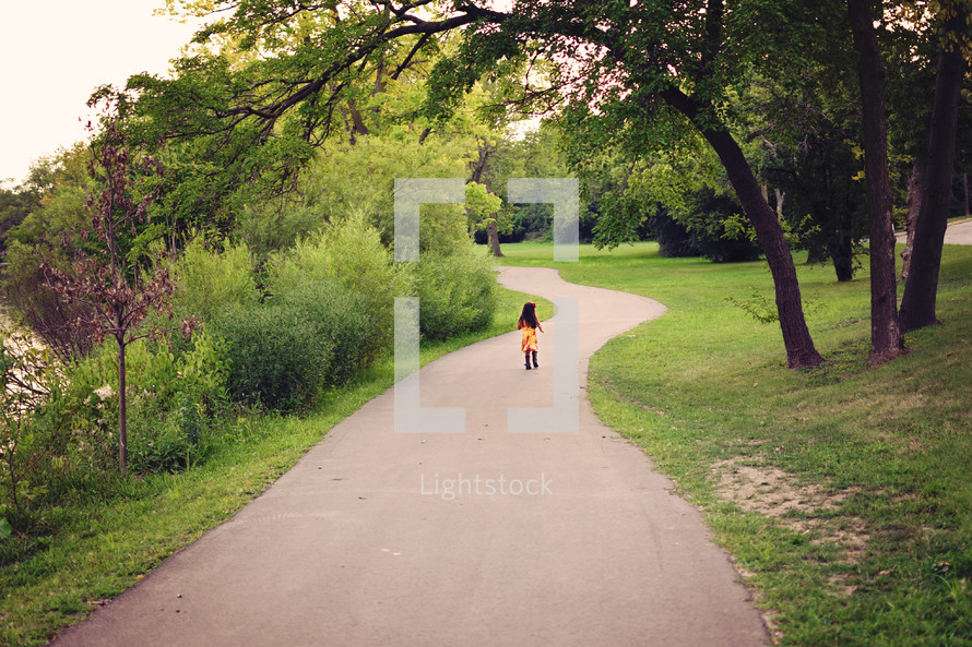little girl walking on a path 