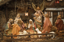 Nativity scene with Baby Jesus, Mary, Josef, shepherds and Magi in front of a stable.