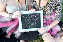 women holding a we love you sign 