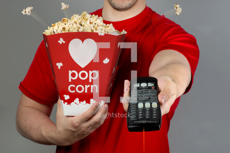 man with popcorn and a remote control 