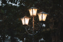 Vintage lit street lamp in the evening