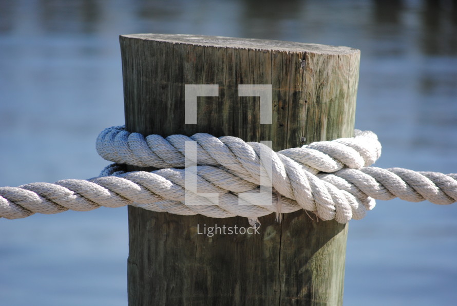 Rope tied to a pier on a lake.