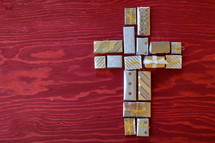 many little presents shaping a cross on red wooden background