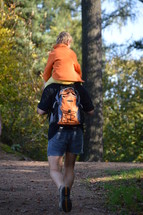 toddler boy riding of his father's shoulder 