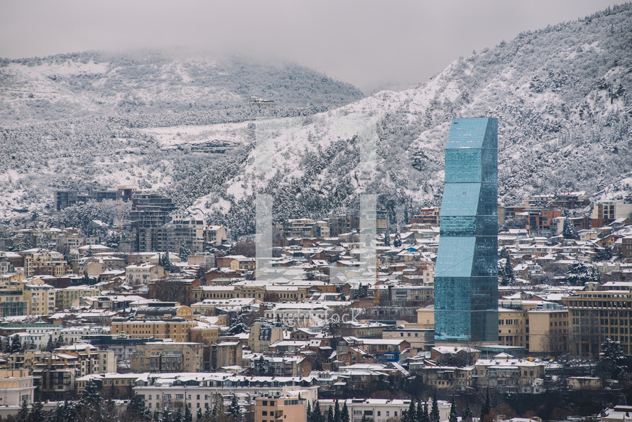 Snowy city and glass skyscraper