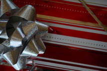 A present wrapped in red striped gift wrap with a silver bow.