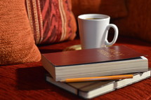 coffee mug, Bible, journal, and pencil on a couch - comfortable bible study at home 
