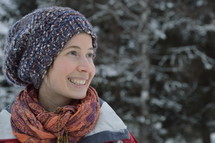 a smiling woman wearing a beanie in the snow 