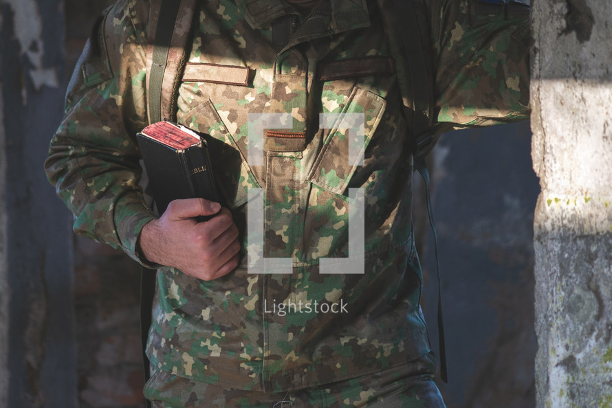 man in military uniform holding a Bible 