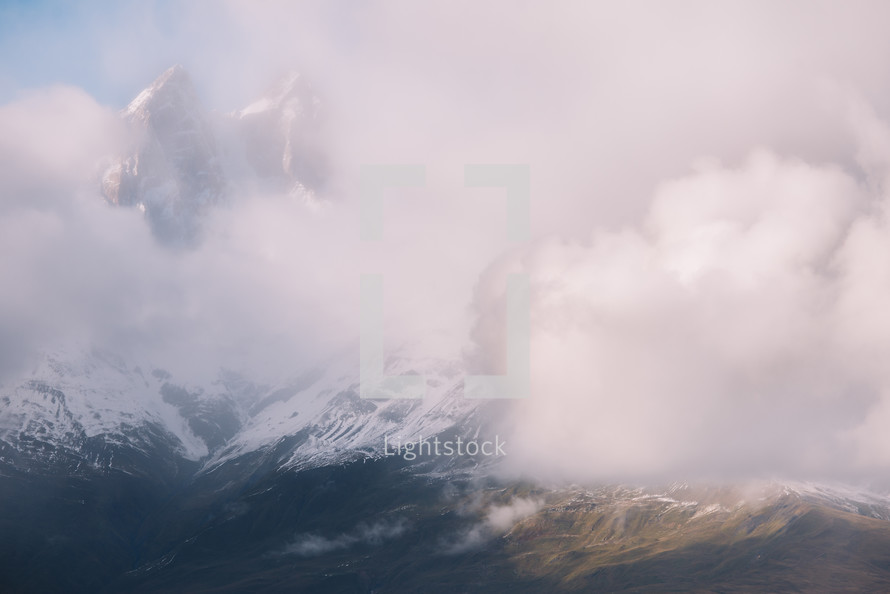 Clouds and snowy peaks