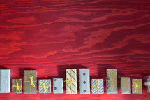 many little presents building a border on red wooden background