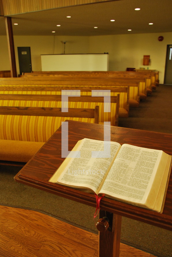 Bible at the pulpit and rows of church pews 