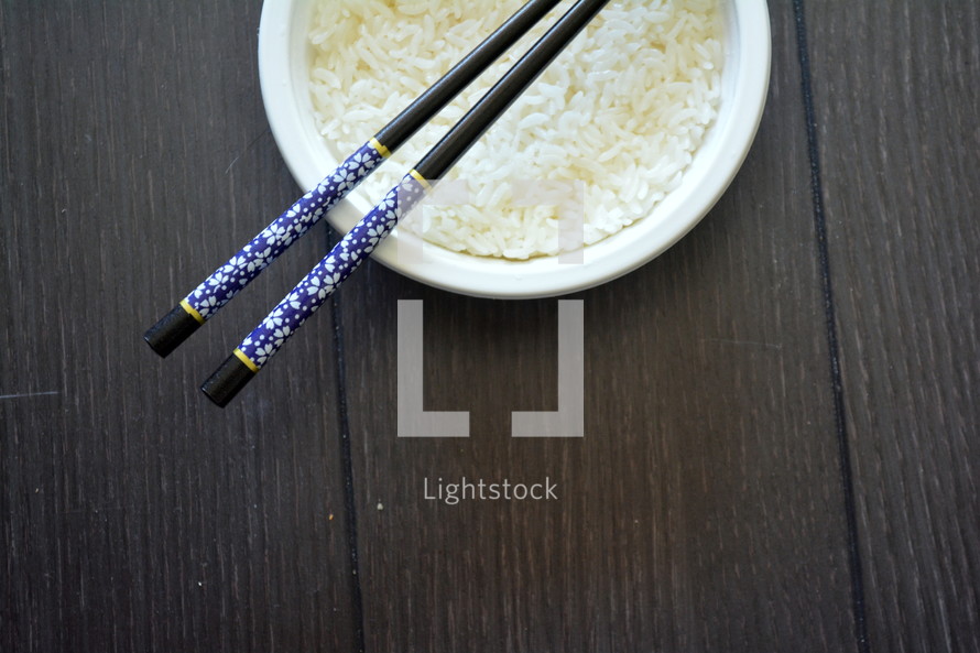 chop sticks in a bowl of rice 