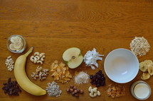 dried fruits, fruit, nuts, and grains 
heaps with choice of cereals for breakfast on wooden table 