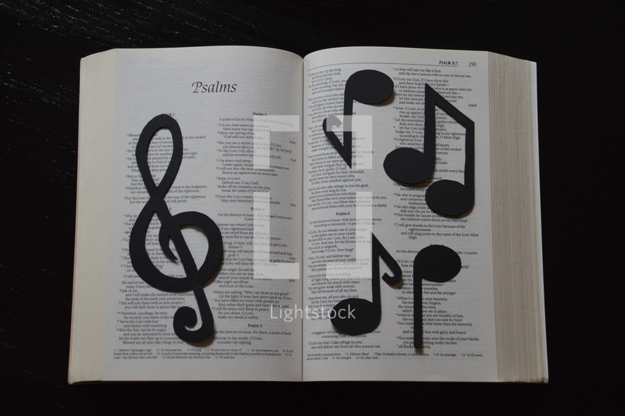 Bible open to Psalms covered in musical notes.