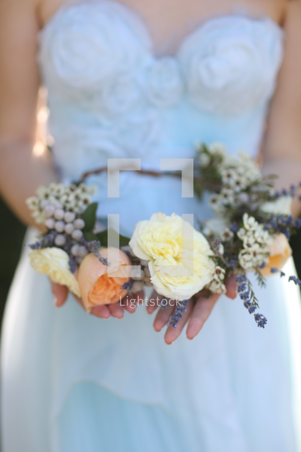 bride holding a crown of flowers 
