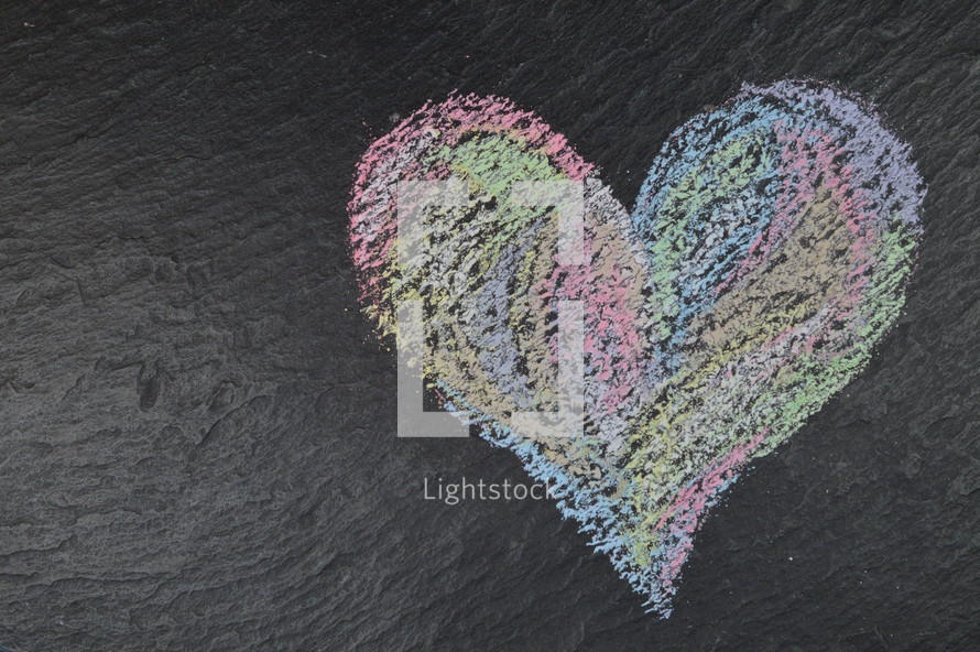 heart shape in sidewalk chalk on slate with copy space to the left