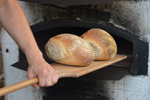 Removing freshly baked bread from a stone oven.