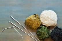 balls of yarn and knitting needles on a cyan table