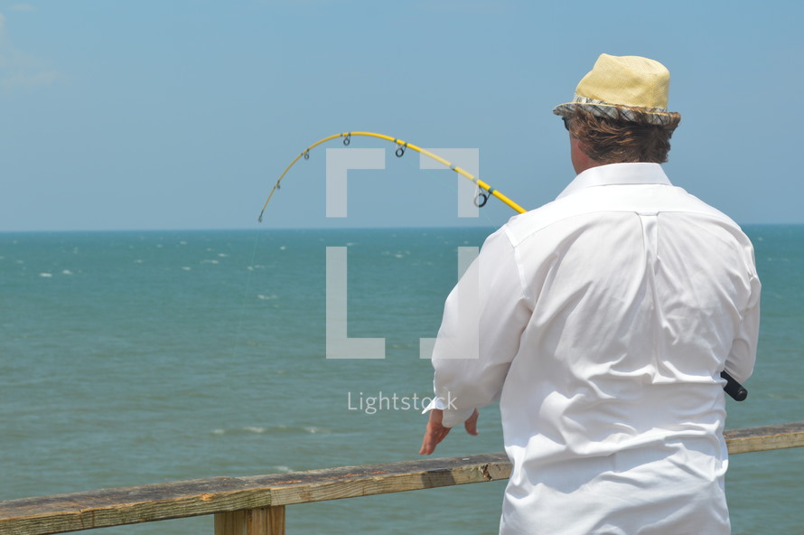 man fishing on a pier 