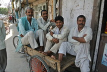 men sitting in a pedicab wagon