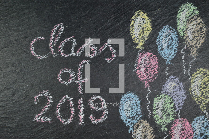 chalk on slate with balloons and the words: class of 2019