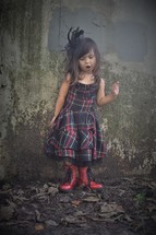 a little girl all dressed up standing in fall leaves 