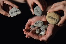 People are giving their worries in the symbol of stones into the hands of Jesus.