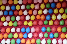 colorful balloons pinned at a pink wall at a fair