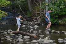 father and son exploring a creek
