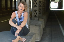 self-confident punk woman sitting under an overpass 