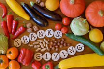 fruits and vegetables with burned wood showing the word thanksgiving