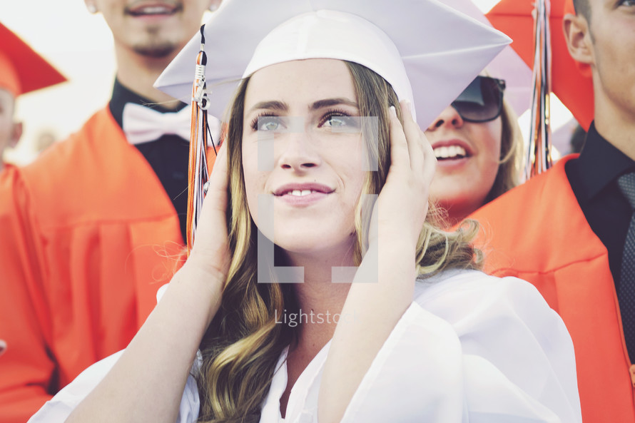 graduate covering her ears 