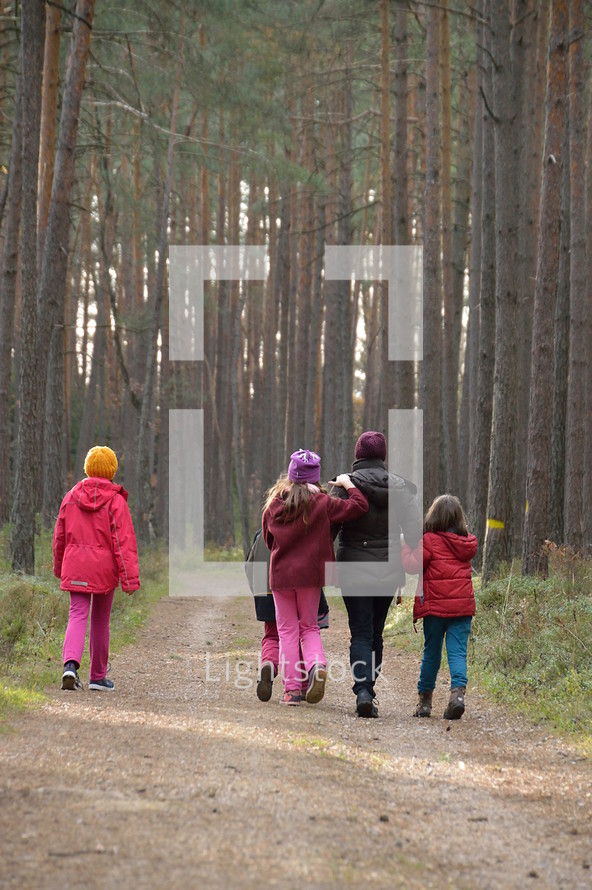 a family hiking on a path in a forest 