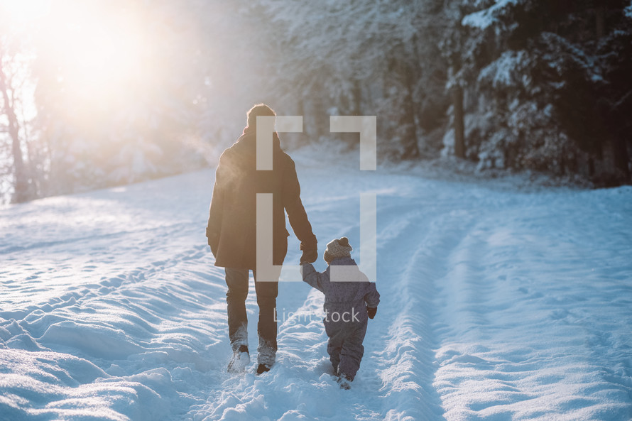 Father and son go for a walk in the snow