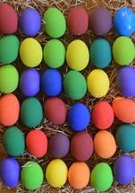 Colorfully painted Easter eggs on straw.
