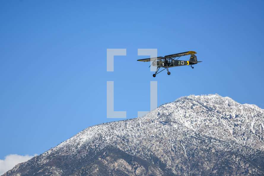 small plane flying around mountains 