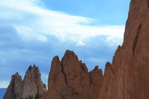 jagged rugged red rock peaks against a blue sky 
