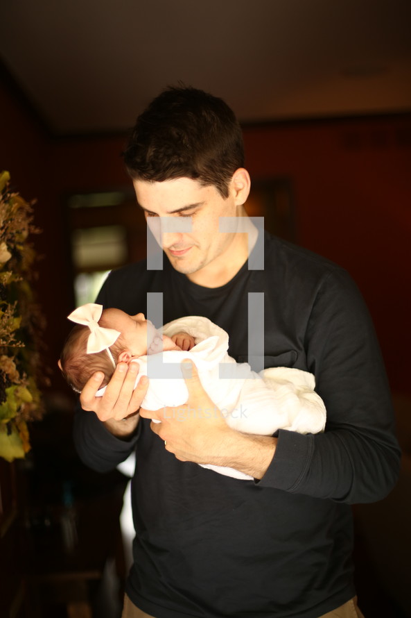 a father holding his newborn infant 