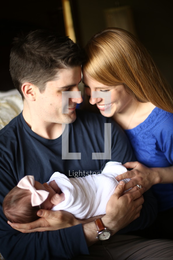 a mother and father holding a newborn infant 