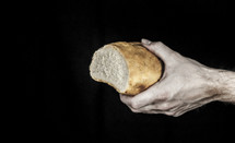 hand holding a loaf of bread 