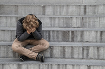child sitting on steps crying 