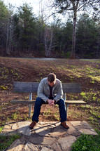 man, head bowed, praying hands, prayer, sitting, bench, outdoors 
