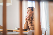 a woman sitting reading a Bible and praying 