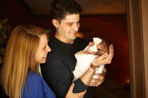 a mother and father holding their newborn baby 