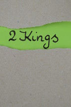 torn open kraft paper over green paper with the name of the book 2 Kings