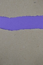 torn gray paper with exposed purple underneath 